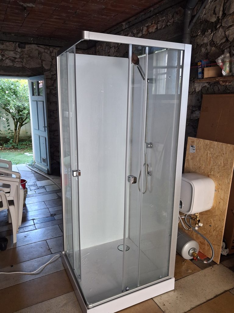 Installation d'une cabine de douche provisoire dans un garage pendant des travaux de salle de bain
